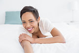 Smiling pretty young woman relaxing in bed