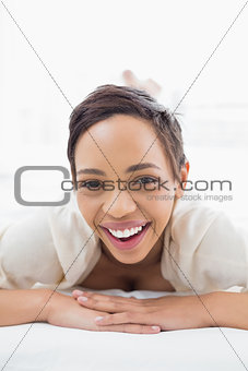 Cheerful pretty young woman relaxing in bed