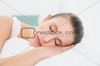 Pretty woman sleeping with eyes closed in bed
