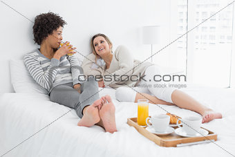 Female friends having breakfast in bed