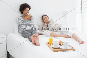 Female friends having breakfast in bed