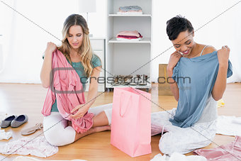 Women on floor with clothes and shopping bag