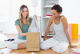 Women sitting on the floor with shopping bag