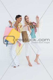 Smiling young women standing with shopping bags
