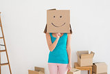 Woman in blue tank top with smiley cardboard box over face