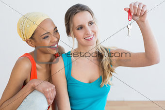 Two happy female friends with house keys