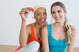Two cheerful female friends with house keys