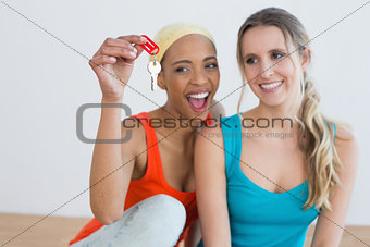 Two cheerful female friends with house keys