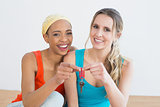 Portrait of two cheerful female friends with house keys