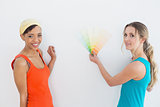 Female friends choosing color for painting a room
