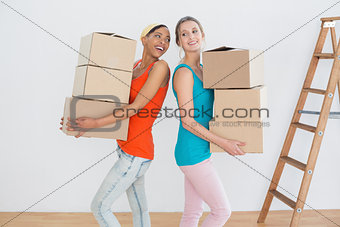 Cheerful friends moving together in a new house