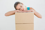 Pretty young woman resting head over a stack of boxes