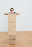 Woman moving in a new house with a stack of boxes