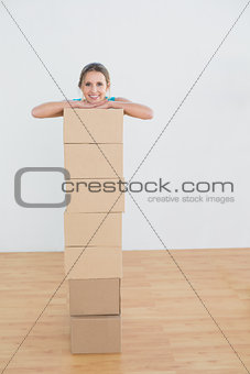 Woman moving in a new house with a stack of boxes