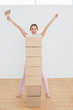 Woman with stack of boxes and paintbrush in a new house
