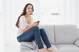 Relaxed woman text messaging on sofa at home