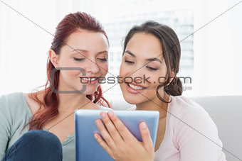 Close-up of young female friends using digital tablet