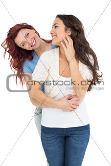 Young female embracing her friend from behind