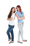 Full length of two female friends with arms crossed