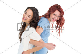 Young women standing back to back with interlocked hands