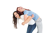 Young woman carrying female friend on back