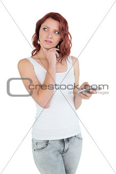 Thoughtful casual young woman with mobile phone