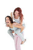 Cheerful young female piggybacking happy friend