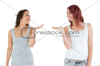 Two happy young female friends holding out their hands