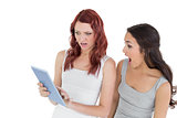 Shocked female friends looking at digital tablet