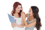 Two shocked young female friends with digital tablet
