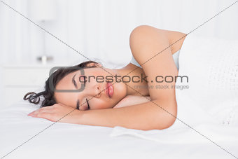 Pretty young woman sleeping with eyes closed in bed