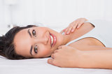 Close-up of a smiling pretty woman relaxing in bed