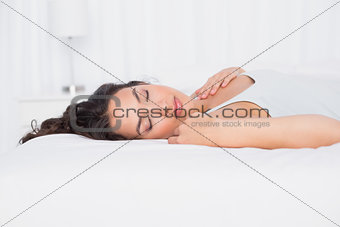 Pretty young woman sleeping with eyes closed in bed