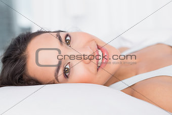 Close-up of a smiling pretty woman lying in bed