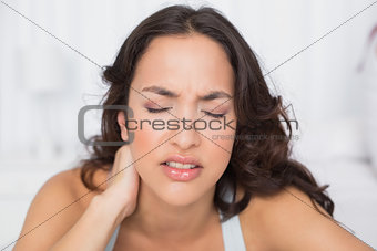 Woman suffering from neck pain with eyes closed