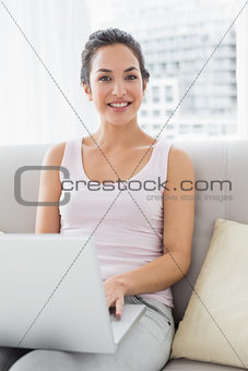 Portrait of a relaxed young woman using laptop on sofa