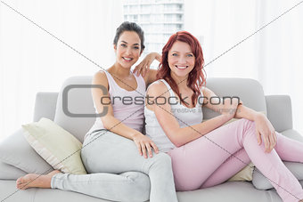 Two beautiful young female friends in living room