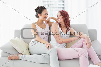 Smiling beautiful female friends in living room