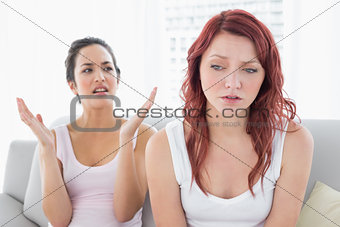 Angry female friends having an argument in living room