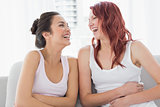 Beautiful young female friends laughing in living room