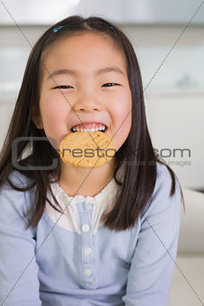 Portrait of a smiling young girl enjoying cookies