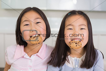 Portrait of two smiling young girls enjoying cookies