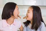 Two girls enjoying cookies in the kitchen