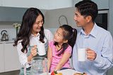 Happy young girl enjoying breakfast with parents