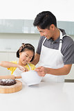 Man with his young daughter preparing food in kitchen