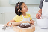 Smiling girl with her father preparing cookies in kitchen