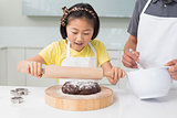 Smiling girl with her father preparing cookies in kitchen