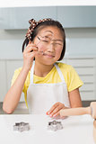 Portrait of a smiling young girl holding cookie mold in kitchen