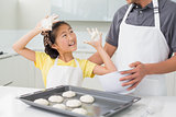Cheerful girl with her father preparing cookies in kitchen