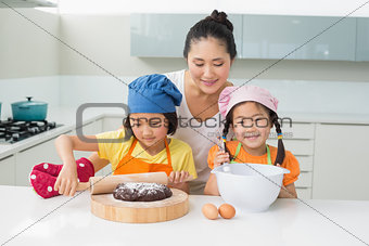 Girls with their mother preparing cookies in kitchen